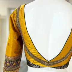 The deep V-back on this yellow and black brocade blouse creates a bold and dramatic silhouette, perfect for making a statement.