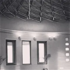 The interior of the completed yoga hall, showing how the bamboo roof structure meets the mud-plastered walls. This combination of earth and bamboo creates a space that feels organic, calming, and deeply connected to nature.