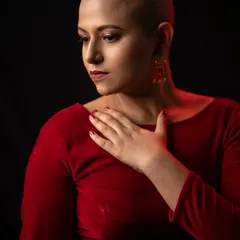 This artistic shot uses dramatic lighting to highlight the contours of her face and the flawless makeup application, creating a mood of quiet confidence and strength.