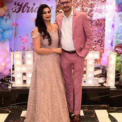 This couple is ready for a party. He stands out in a stylish pink suit, showing that I offer modern and colorful options beyond traditional black-tie attire.