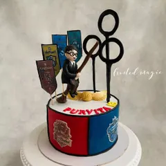Calling all Potterheads! This Harry Potter themed cake features a hand-sculpted Harry on his broomstick, Quidditch hoops, and the house banners of Hogwarts. It's pure magic for a fan's birthday.