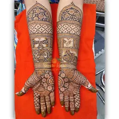 This full-coverage design for the groom's mother incorporates traditional elements like the shehnai and kalash, symbolizing auspicious beginnings.