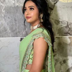 A side profile showing the soft, shimmery eye makeup that catches the light beautifully. This look is elegant and perfect for a wedding guest.
