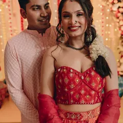 A beautiful couple at their Mehendi function. The bride-to-be's makeup is fresh and gorgeous, with a bright smile that lights up the photo.