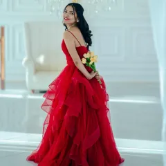 A playful and elegant pose showing off the full, layered skirt of the red ballgown. She looks absolutely breathtaking.