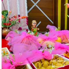 The details matter in a traditional ceremony. Here, we have arranged return gifts wrapped in bright pink tulle alongside a traditional Marapachi Bommai doll, adding a touch of cultural charm and color to the event.