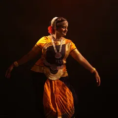 A graceful portrait of a Bharatanatyam dancer in mid-pose. I offer authentic classical dance costumes and jewelry for rent, captured with dramatic studio lighting.