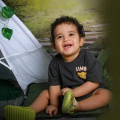 A happy camper in our forest-themed studio. This little explorer's smile is as bright as a campfire, perfectly capturing the joy of adventure.