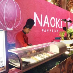 Our "Naoki Pan Asian" sushi station, where a chef meticulously prepares fresh sushi rolls. The station is beautifully branded and lit, becoming a visual and culinary highlight of the event.