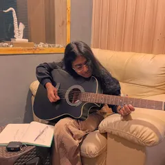 A student works on her songwriting and guitar skills in one of our cozy practice corners. With flexible scheduling, you can book sessions that fit your routine.