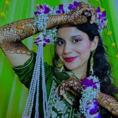 A stunning bride adorned with a floral crown and matching floral henna jewelry, perfectly complementing her intricate mehndi.