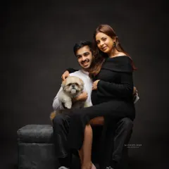 A stylish and modern family portrait with their adorable dog. This studio shot shows that pets are always welcome to join in the celebration.