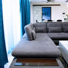 We call this living space "The Hall of Play." We kept the design minimal to respect the white space, using a large sectional sofa and bright blue curtains to add comfort and a pop of color.