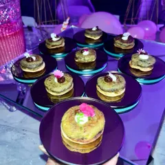 A mini pancake stack appetizer, beautifully garnished and served on a mirrored plate, from the chic Sweet 16 celebration.