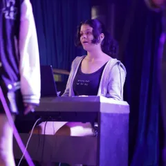 A keyboardist holds down the harmony for her band. Playing in an ensemble teaches you how your part fits into the bigger picture, a core focus of our band coaching program.