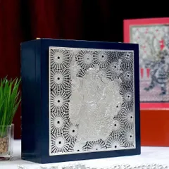 This deep blue gift box showcases a silver-plated Radha Krishna motif, capturing a moment of divine love. The intricate silverwork against the rich blue creates a stunning visual, perfect for wedding or anniversary gifting.