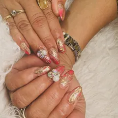 A fiery and glamorous set. These nails feature a pink and gold marble effect with gold foil and stunning 3D gem clusters.