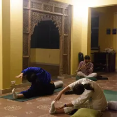 Participants flowing through asanas in a tranquil shala during our Dehradun retreat. These moments of shared practice, surrounded by nature and accompanied by live flute music, create a space for connection and growth.