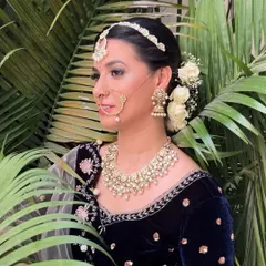 A profile view showing the elegant matha patti and the white rose bun.