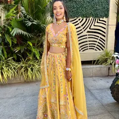 A full-length shot of the bride, looking radiant and joyful in her yellow ensemble.