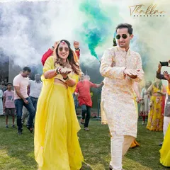 We love creating high energy moments. Here, the bride and groom make a grand entry at their Haldi celebration, dancing through clouds of vibrant, non toxic color smoke for a truly cinematic shot.