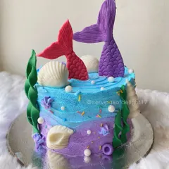 An enchanting mermaid theme cake, perfect for an under-the-sea party. I used shades of blue and purple buttercream and added handcrafted mermaid tails and seashells.