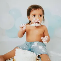 Cake smash sessions are just as fun for boys. This little guy is digging into his first birthday cake with gusto during a simple and classic blue and white themed shoot in my Faridabad studio.