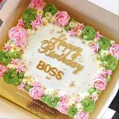 A beautiful floral sheet cake for a "Happy Birthday Boss" celebration. The piped rosettes in pink and green make it an elegant option for a corporate event or large office party.