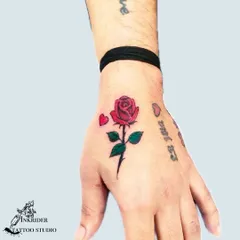 A small color rose tattoo on the hand, used here to cover faded script. This demonstrates how even a small, colorful design can be an effective cover-up solution.