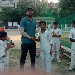 Coach Anuj presenting the Man of the Match trophy to Prashant Yadav for his match-winning 52 runs. We make sure every outstanding performance is recognized.