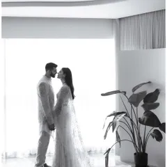 A wide, minimalist shot of them about to kiss, framed by the clean lines of a modern room. The black and white treatment adds a timeless, architectural quality.