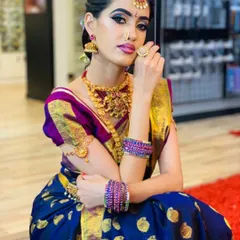 A complete traditional look for a South Indian bride. Notice the sharp, winged eyeliner and the perfectly matched lip color that brings the whole look together with the rich blue and gold silk saree.