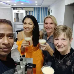 A happy group selfie after a successful private cocktail workshop. Everyone is holding the delicious drinks they just learned how to make themselves.