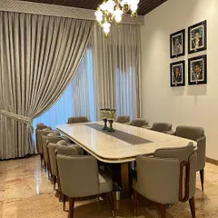 Every detail is considered, from the brass-tipped legs of the chairs to the curated art on the walls, ensuring a cohesive and luxurious dining experience.