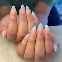 A fresh take on a classic. These flawless French nails feature a clean, sheer pink base and crisp baby blue tips on elegant, almond-shaped extensions.