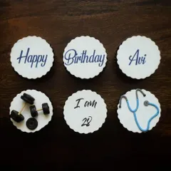 A top-down view of the custom cupcake toppers for a doctor and gym junkie. You can see the detail in the fondant stethoscope and the miniature weights, making it a truly personalized birthday gift.