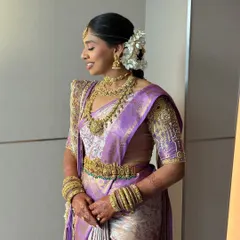 A candid side profile, showing the elegant bridal updo adorned with a cascade of fresh white flowers, a hallmark of South Indian bridal style.