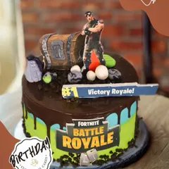Victory Royale! This Fortnite-themed cake is perfect for a battle royale fan, featuring a loot chest, a character, and the iconic game logo.