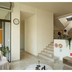 This view shows the multiple levels and connections within the home, from the living area to the stairs and the small balcony. The design encourages movement and interaction.