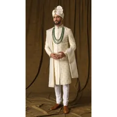 This pearl ivory sherwani, named 'ARAMBH', is crafted from fine silk and features mesmerizing vine motifs with rose gold accents. Paired with a shimmering dupatta, it signifies a beautiful new beginning.