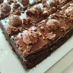 Indulge in our Ferrero Rocher pastry. This slice of rich chocolate cake is topped with a decadent chocolate hazelnut ganache and crushed Ferrero Rocher pieces.