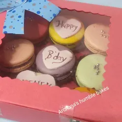 A personalized birthday macaron box, all packed up and ready to be gifted. The window on the box gives a beautiful sneak peek of the colorful and custom treats inside.