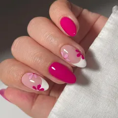 A modern and romantic floral design. This set combines solid magenta nails with negative space art, featuring pink flowers on a modern French tip for a chic and stylish look.