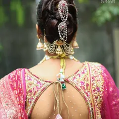 An elegant braided bun adorned with traditional Maharashtrian hair accessories. This hairstyle is perfect for keeping the hair neatly in place while adding a touch of royal charm from the back.
