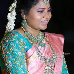 A side profile of the bride, showing the detail on her layered AD stone necklaces and matching jhumkas.