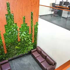 This high-angle view shows how our custom green wall at Amsha Ventures integrates into the multi-level office architecture. The installation provides a natural, calming view for the workspace on the upper floor, enhancing the overall office environment.