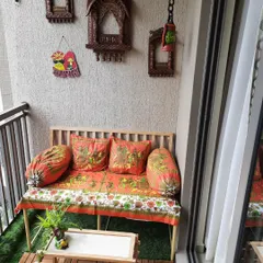 Here is a balcony we designed with a vibrant Rajasthani theme. The custom seating is adorned with traditional block print fabrics, and the wall features carved wooden jharokhas.