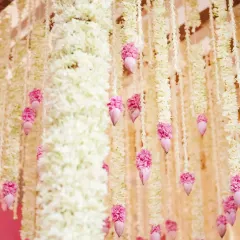 A close-up of the delicate floral strings hanging from our 'Serene Vibes' bamboo pergola. Each string is tipped with a pink lotus bud, creating a beautiful rain-like effect.