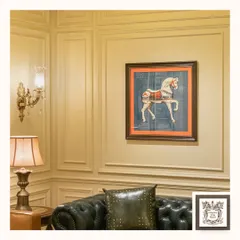 This ornate wall sconce, with its crystal drop and brass details, adds a touch of luxury to this living space. It beautifully complements the classic decor, including the leather sofa and horse-themed wall art.