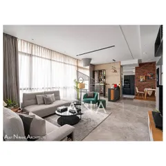 The living area of Apartment 704, showing the open-plan layout connecting the seating area, bar, and breakfast deck. A custom metal partition with mesh subtly divides the bar from the main seating area.